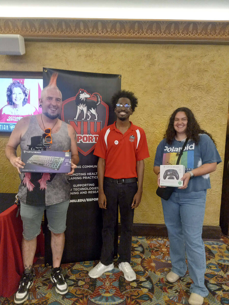 Winners of the Turtle Beach prize packs stand at the NIU Esports booth at Pride Fest.